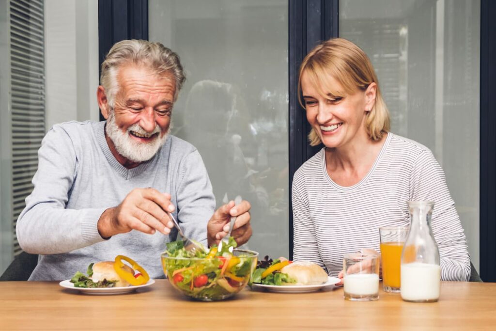 Sage Oak of Denton | Happy senior man and woman eating healthy food - nutrition tips for seniors