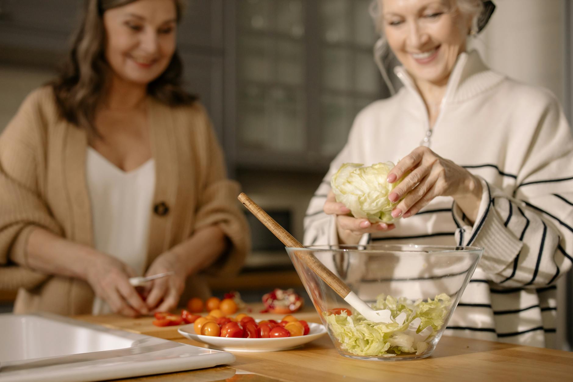 an elderly women preparing fresh salad in the kitchen