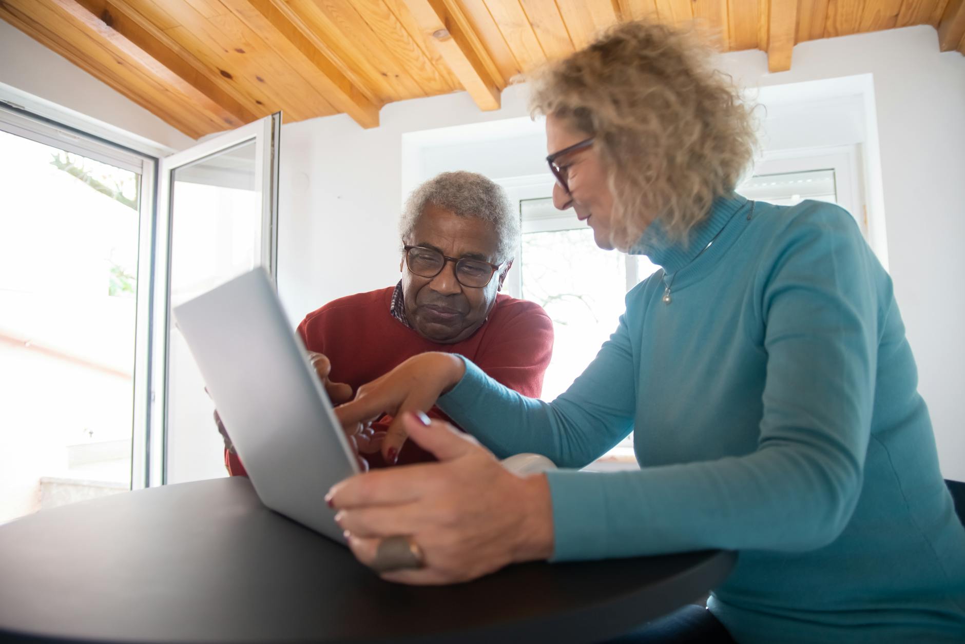 man and woman wearing sweaters using laptop