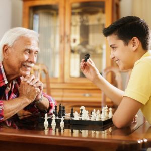 Sage Oak of Denton | Senior man playing chess with grandson